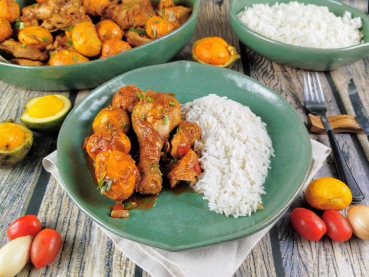 Frango com pequi pronto para consumo, servido com arroz.