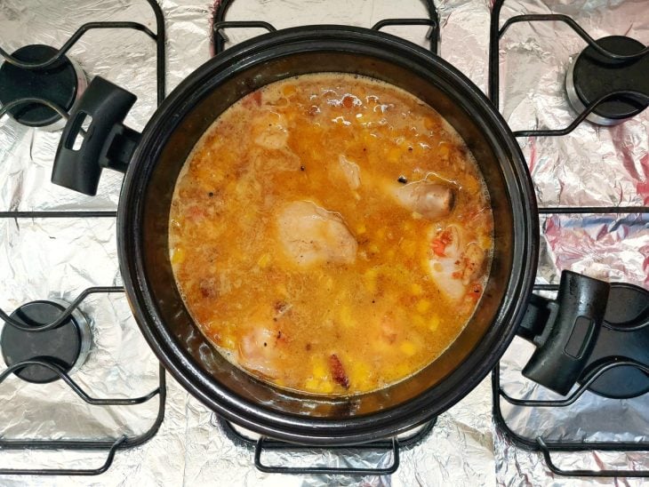 Frango e legumes fervendo na panela.