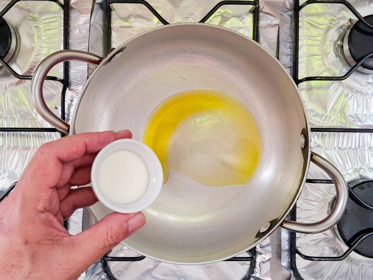 Numa panela, o azeite e o açúcar sendo adicionado para caramelizar.