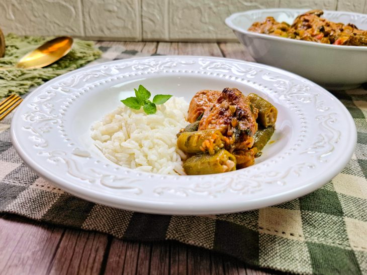 Em um prato, o frango com quiabo servido com arroz branco.