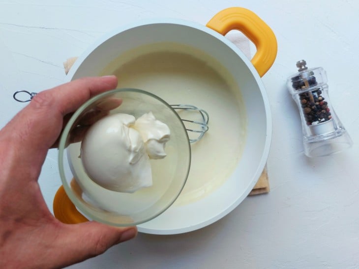 Cream cheese sendo adicionado no molho.