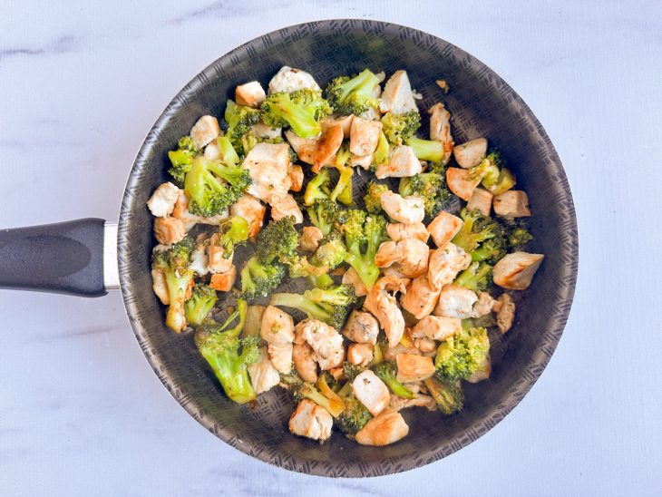 Na frigideira, brócolis adicionado ao frango.
