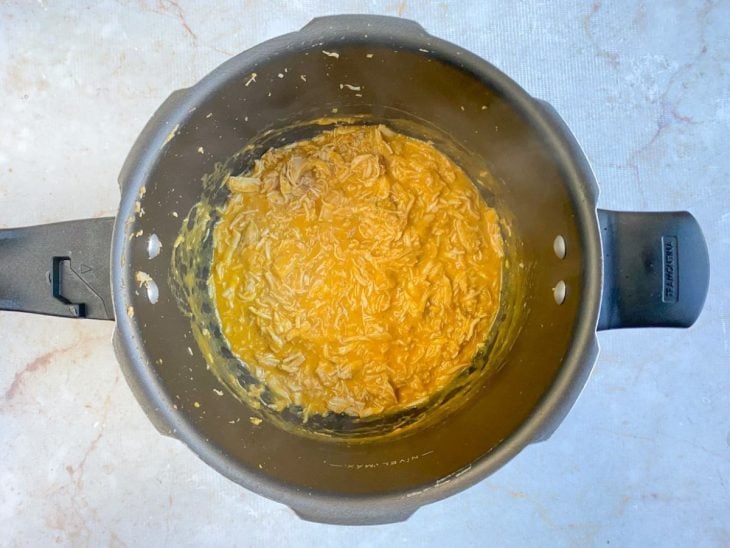 Mistura do liquidificador adicionado a panela de pressão com o frango desfiado.
