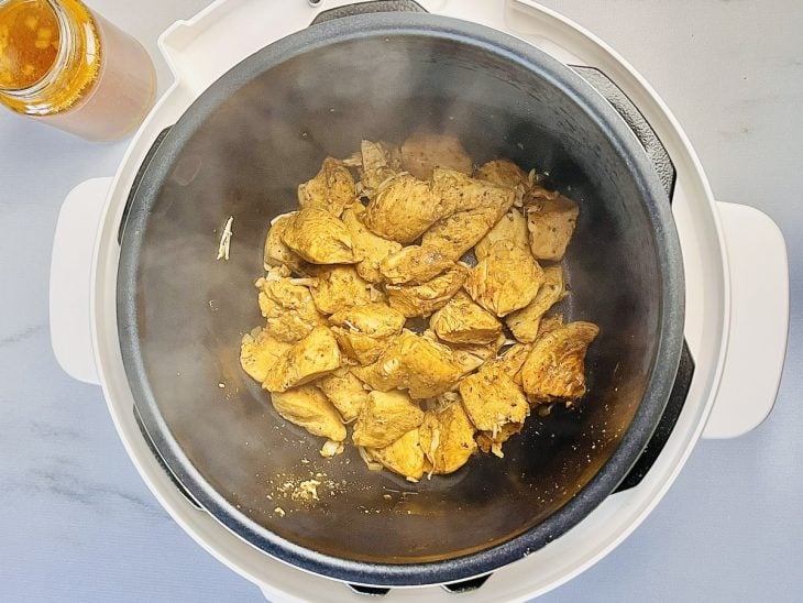 Frango já cozido dentro da panela elétrica.