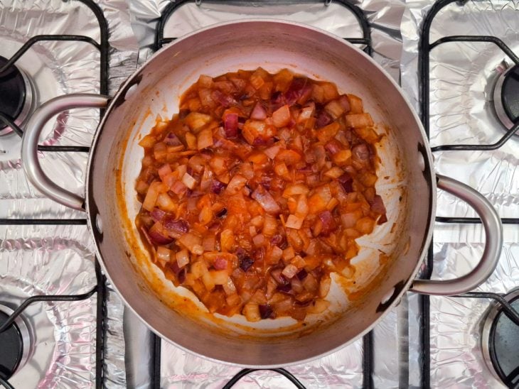 Panela com cebola refogada no azeite e passata de tomate.