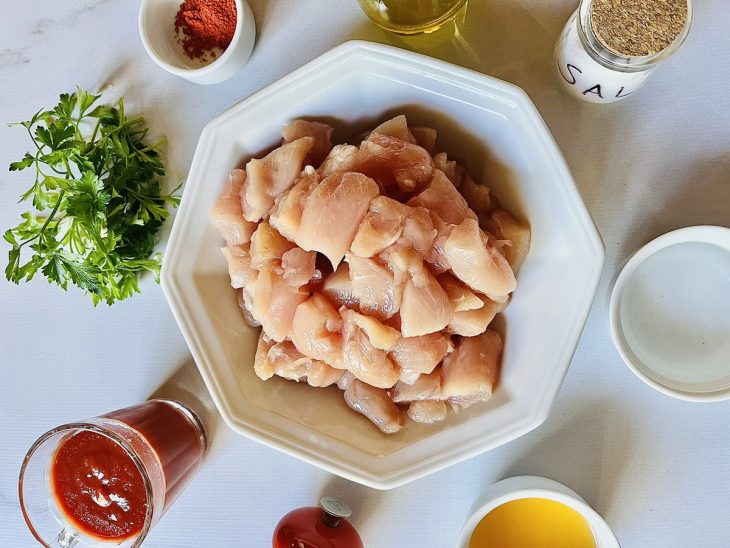 Ingredientes para a receita de frango desfiado reunidos em uma superfície.