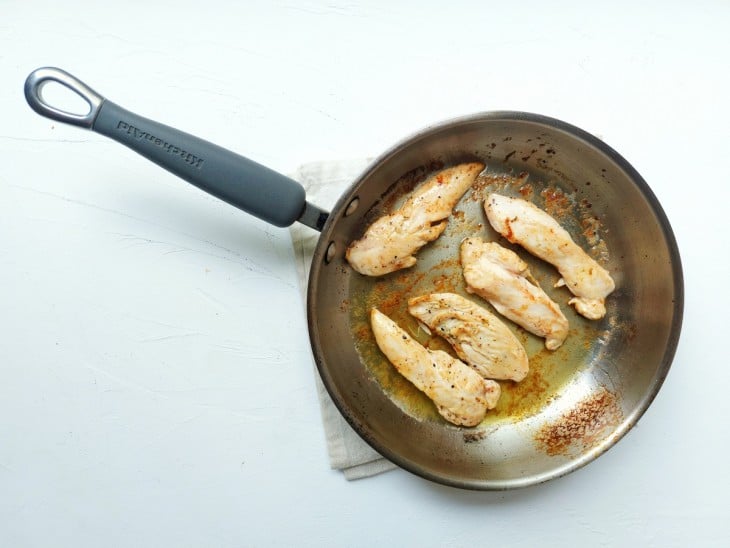 Frigideira com frango levemente dourado.