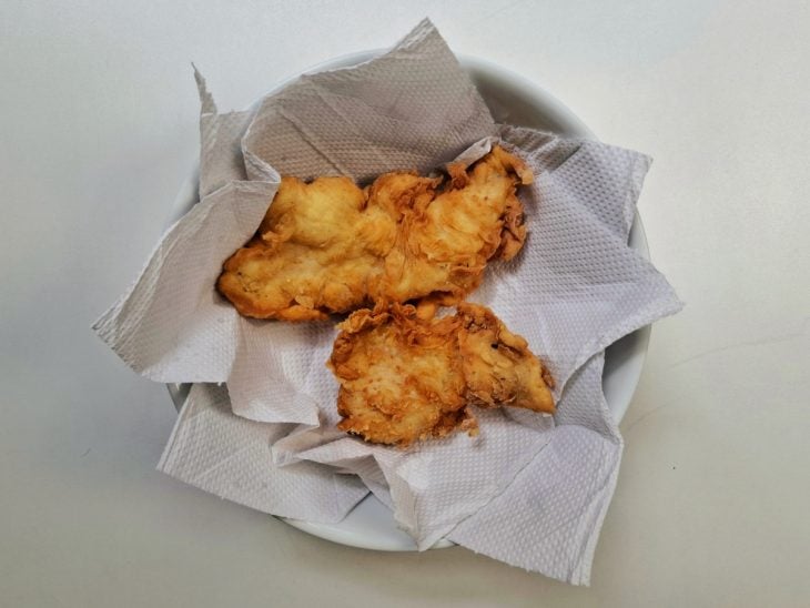 Tiras de frango fritas sobre um prato com papel-toalha.