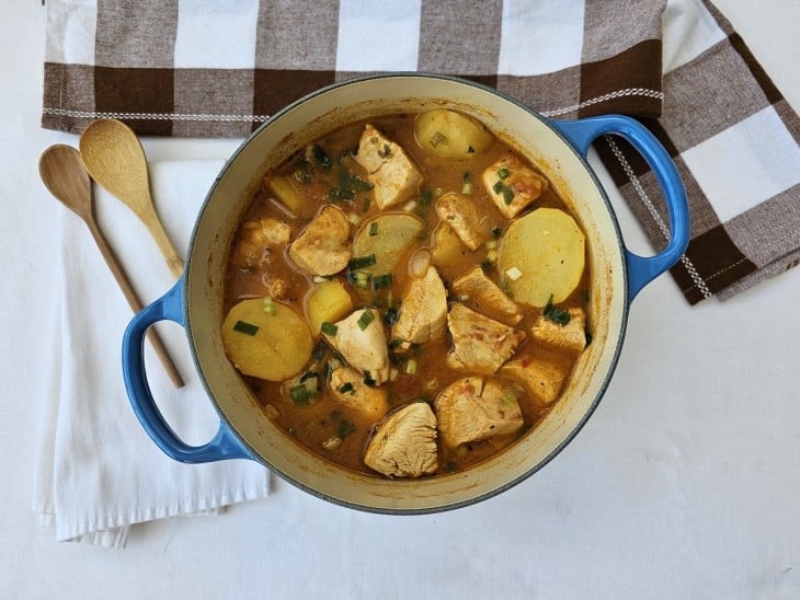 Uma panela contendo frango ensopado com batatas.