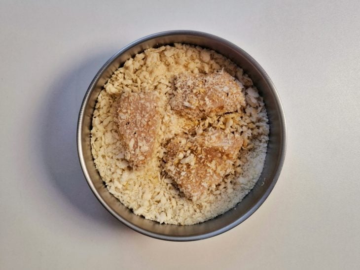 Cubos de frango em uma tigela redonda com farinha Panko.