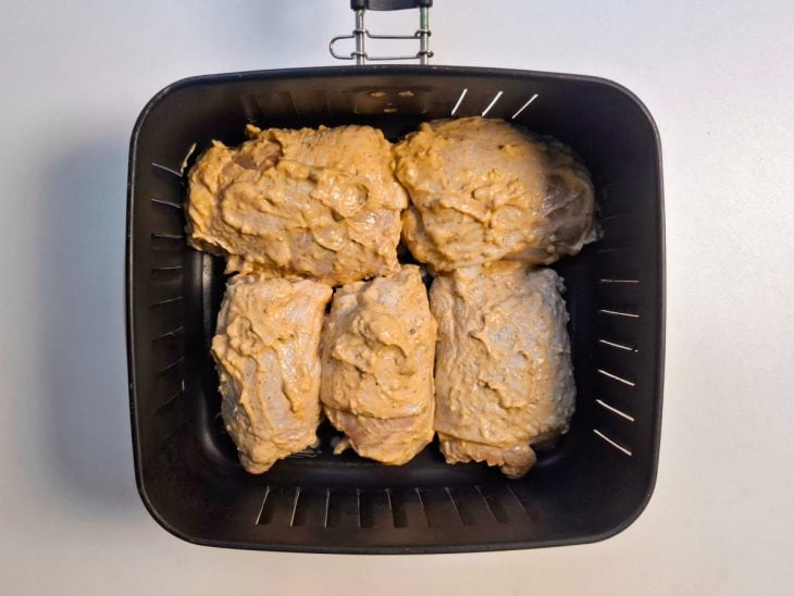 Pedaços de frango acomodados no cesto da Air Fryer.