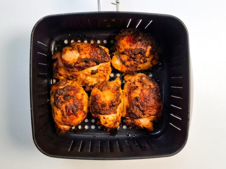 Pedaços de frango virados no cesto da Air Fryer.