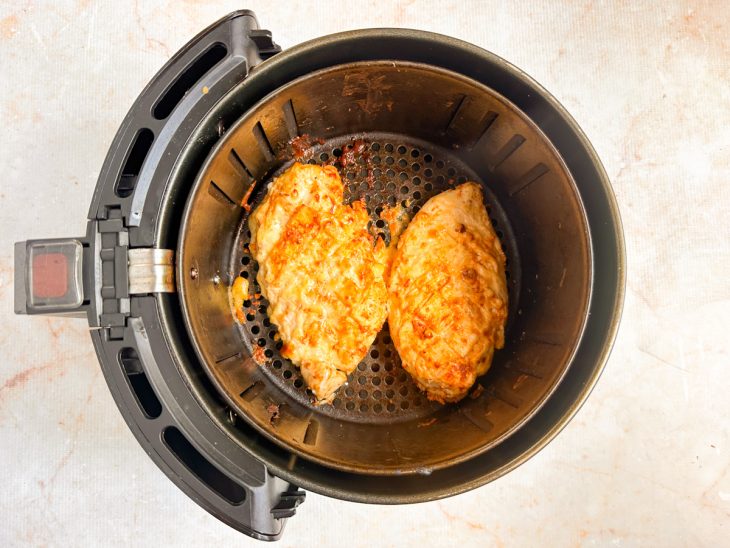 Frango dourando na air fryer durante o preparo.