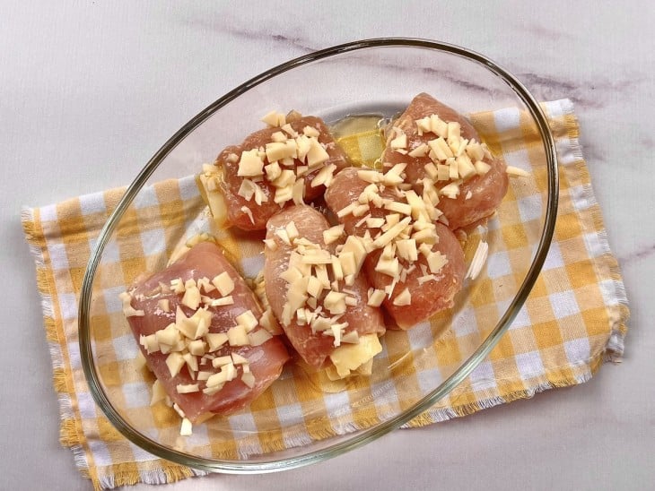 Frangos recheados com queijo salpicado por cima.