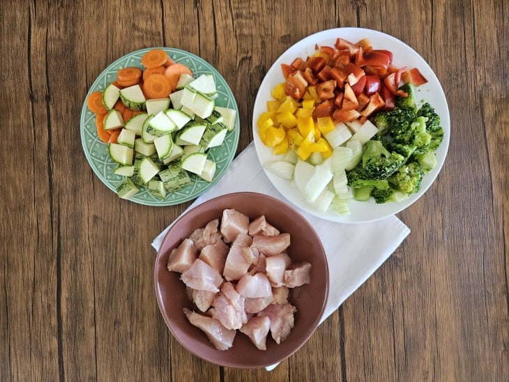 Frango e legumes cortados em pedaços.