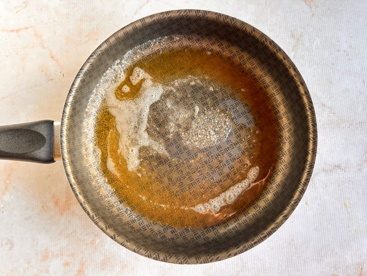 Manteiga derretendo em uma frigideira quente.