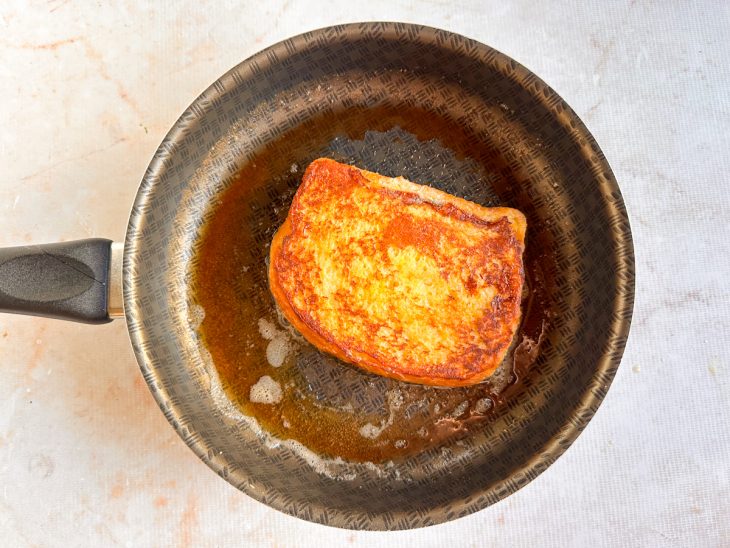 Fatia de brioche sendo dourada na frigideira.