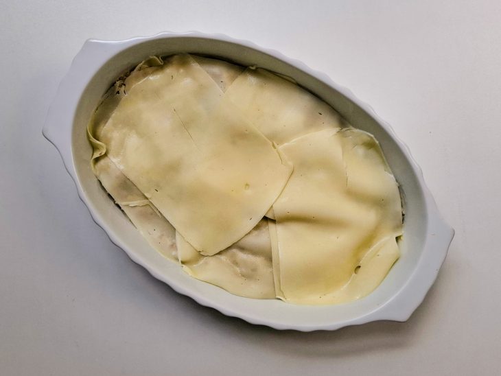 Na travessa, uma camada de queijo por cima da carne.