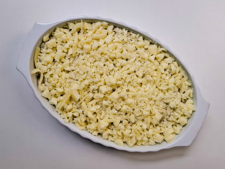 Camada de queijo ralado finalizando a montagem.