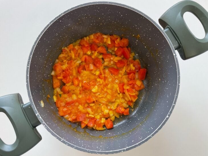 Tomate e temperos adicionados na panela.