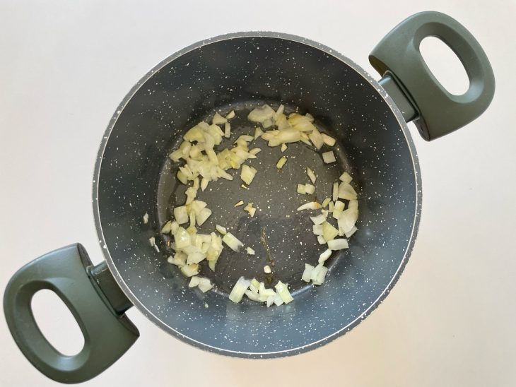 Alho e cebola refogando na panela.