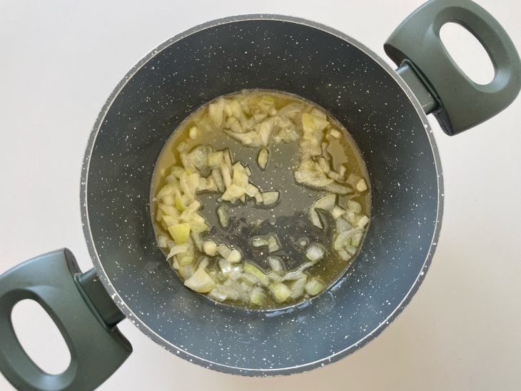 Alho e cebola refogando na panela.