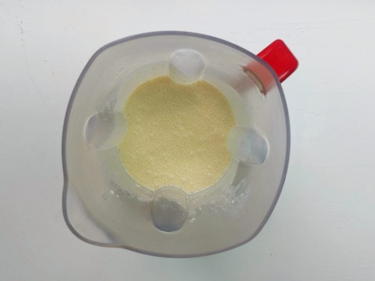 Um liquidificador com a mistura de milho, requeijão, creme de leite e água.