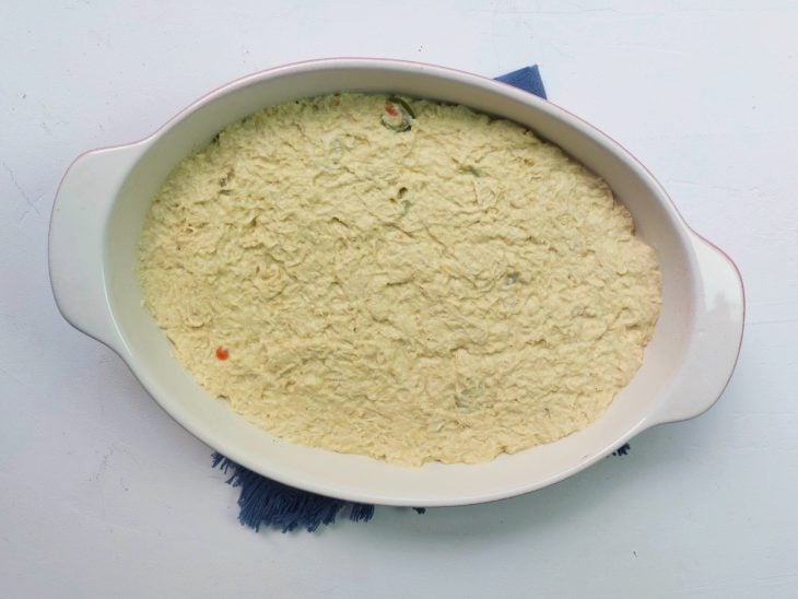 Um refratário com frango desfiado e molho após cozimento.