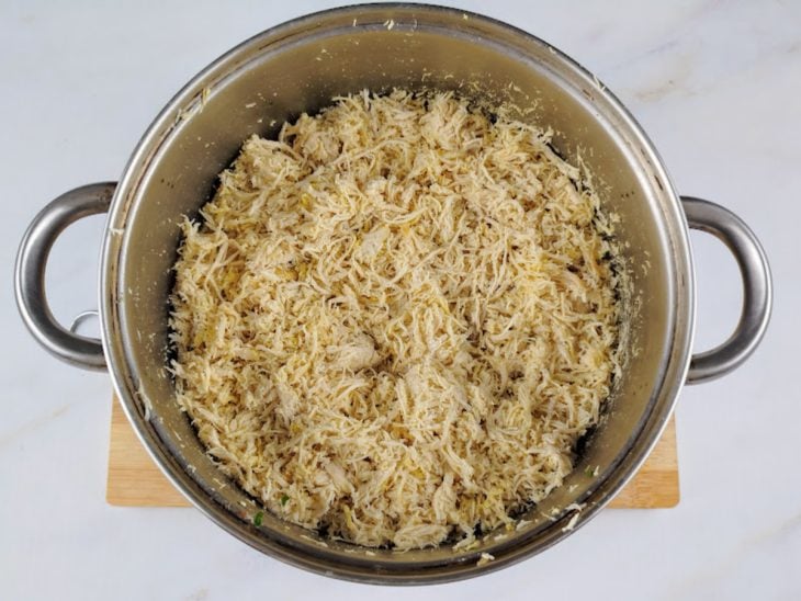 Frango refogado em uma panela com manteiga e temperado com sal.