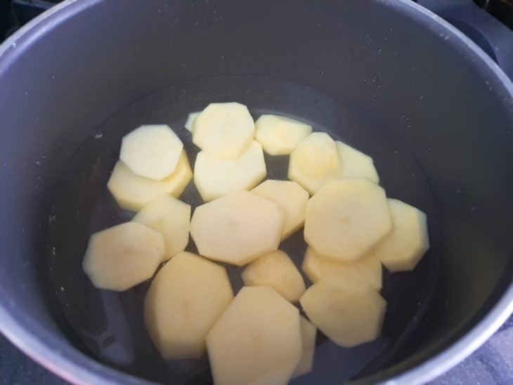 Uma panela com as batatas cozinhando na água.
