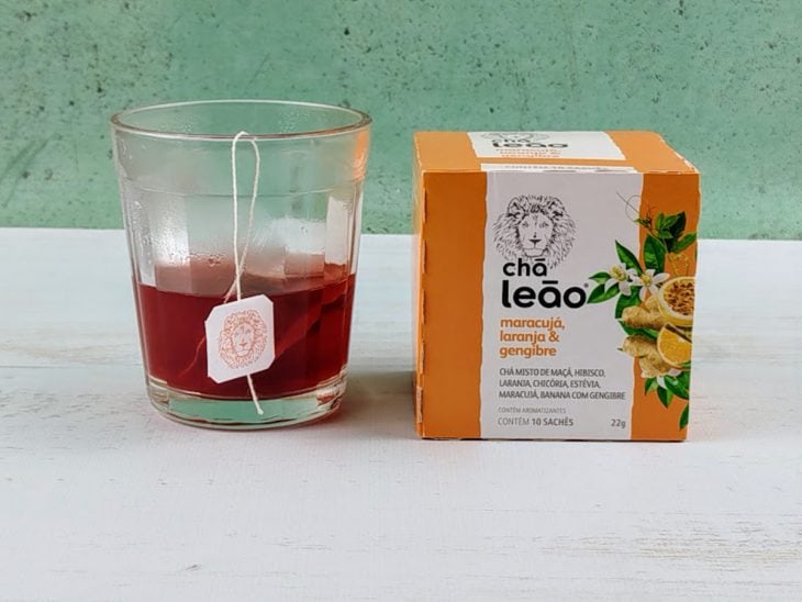 Sachê de chá em infusão em uma xícara de vidro.