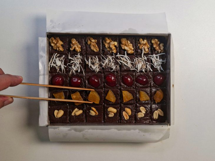 Toppings espalhados sobre os quadradinhos porcionados.