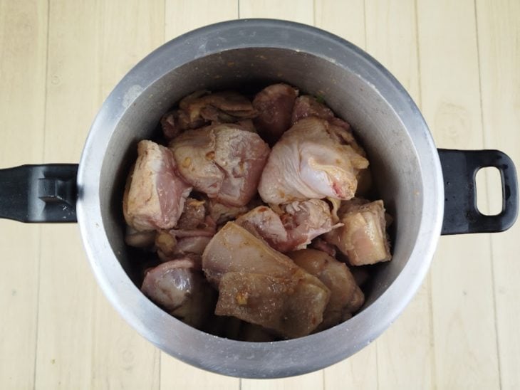 Frango adicionado na panela de pressão.