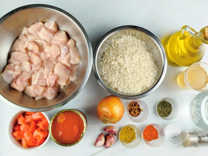 Ingredientes para a receita de galinhada rápida separados em uma bancada.