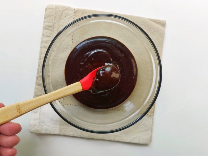 Uma espátula pequena mostrando a consistência da ganache.