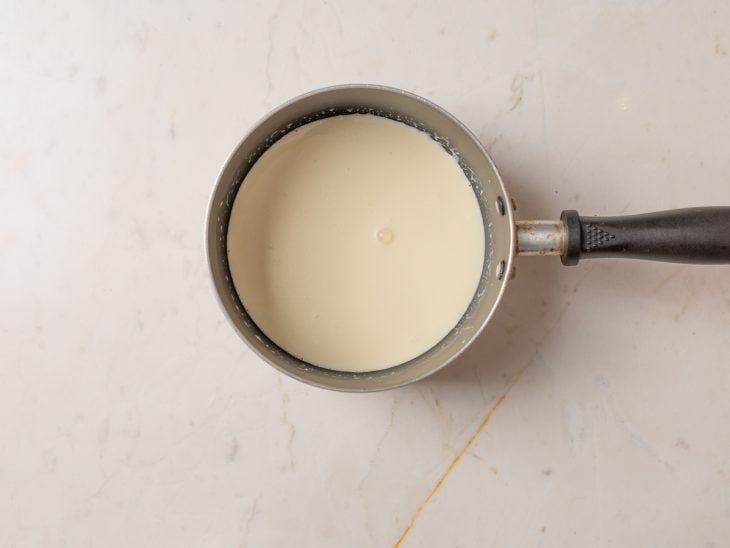 Creme de leite em uma panela para aquecer.
