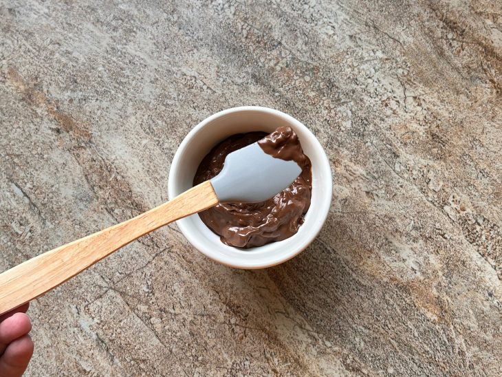 Nutella derretida em um pequeno recipiente de porcelana.