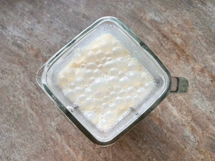 Creme de leite, leite condensado, leite e leite em pó batidos em um liquidificador.