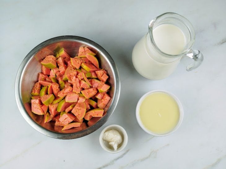 Ingredientes para a receita de geladinho de goiaba reunidos em uma bancada.