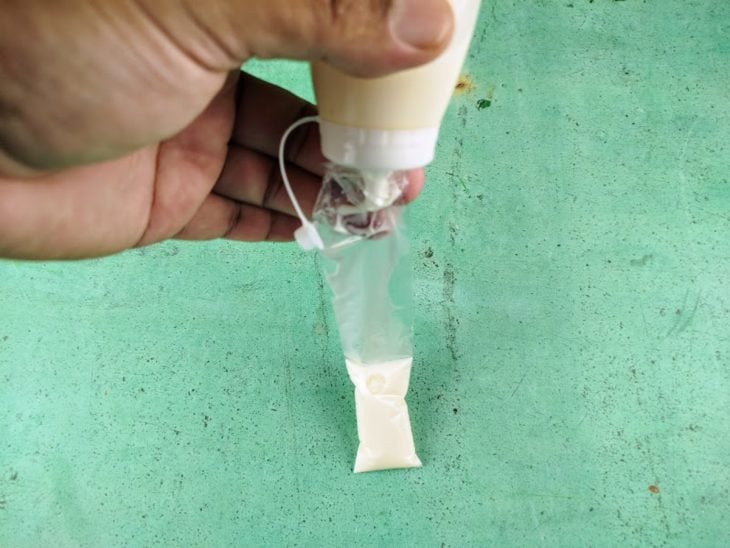 Um saquinho de geladinho com a mistura sendo despejada.