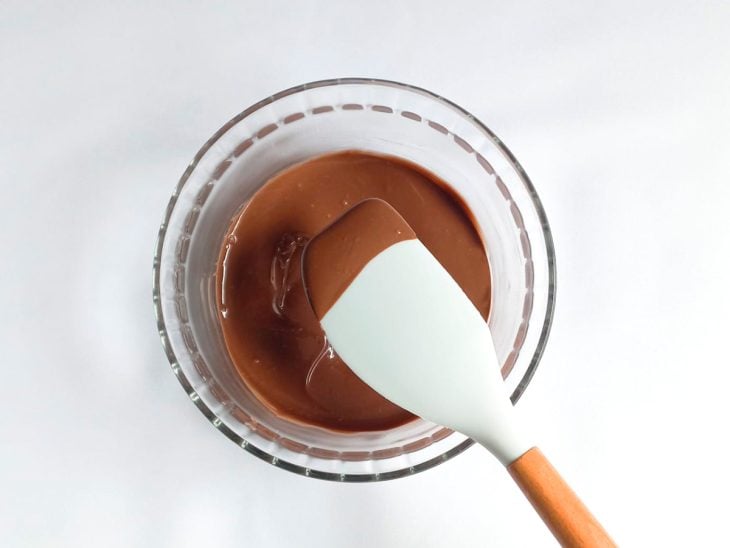 Chocolate derretido em uma tigela redonda de vidro.