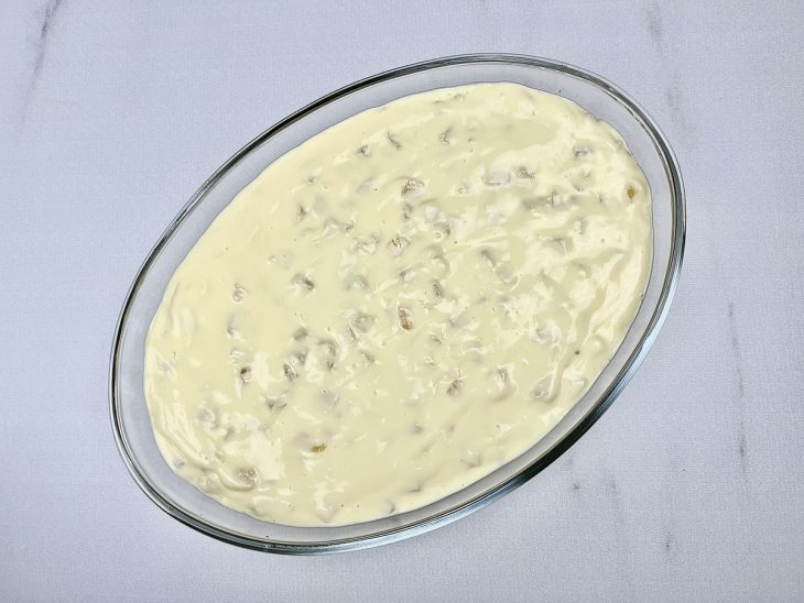 Mistura de creme com abacaxi em um refratário de vidro oval.