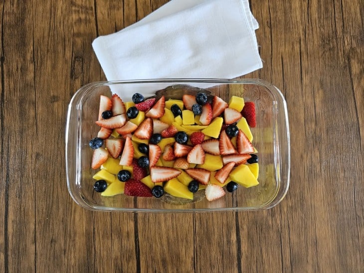 Um refratário com frutas picadas.