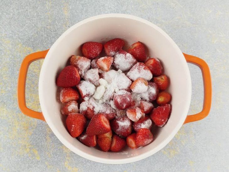 Panela com morango, água e açúcar.
