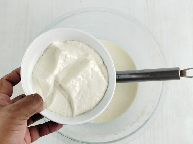 Na tigela, creme de leite sendo adicionado.