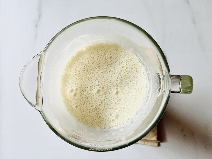 Creme de leite, leite de coco, leite condensado e gelatina incolor hidratada batidos em um liquidificador.