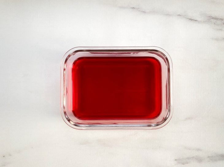 Um recipiente contendo gelatina de morango.