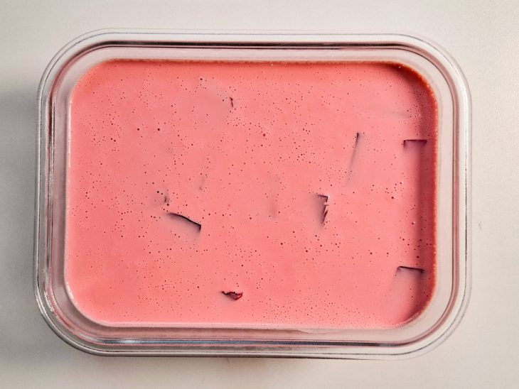 Mistura com creme de leite despejada sobre os cubos de gelatina.