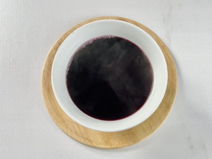 Gelatina de uva sendo dissolvida na água quente até ficar homogênea.