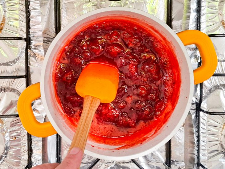 Colher mexendo os morangos.